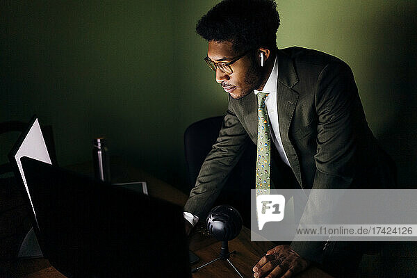 Businessman using computer while standing at home