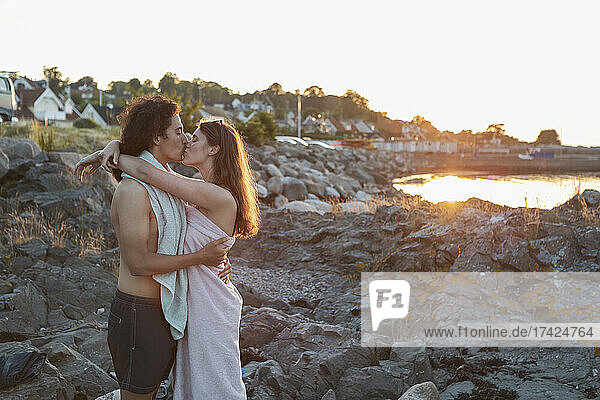 Girlfriend and boyfriend kissing while standing on rock
