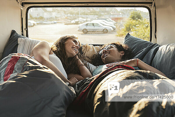 Young couple relaxing while lying in van