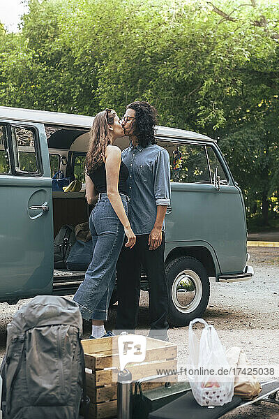 Junges Paar küsst sich außerhalb des Campingwagens
