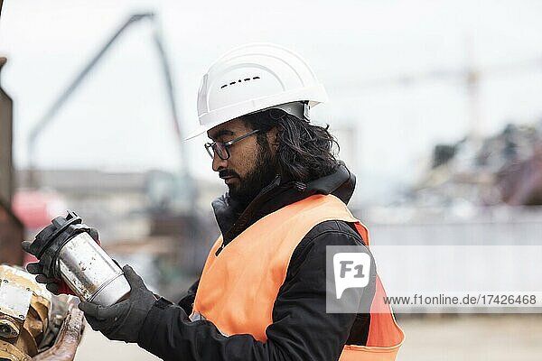 Technician with beard and helmet working in a recycling yard  Freiburg  Baden-Württemberg  Germany  Europe