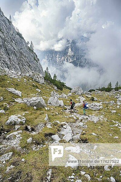 Two hikers descending through the Ofental valley  mountain landscape  Berchtesgaden Alps  Berchtesgadener Land  Upper Bavaria  Bavaria  Germany  Europe