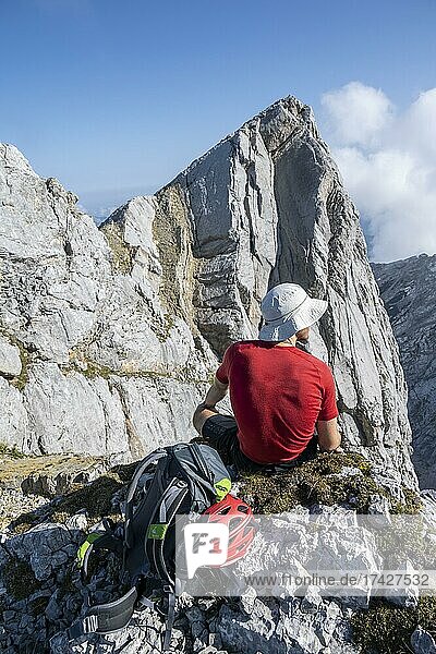 Wanderer macht Pause und sitzt auf einem Stein  Wanderung zum Hochkalter  Berchtesgadener Alpen  Berchtesgadener Land  Oberbayern  Bayern  Deutschland  Europa