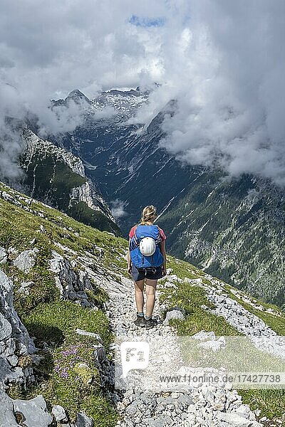 Hiker on a hiking trail  Reintal at the back  Wetterstein Mountains  Garmisch-Partenkirchen  Bavaria  Germany  Europe