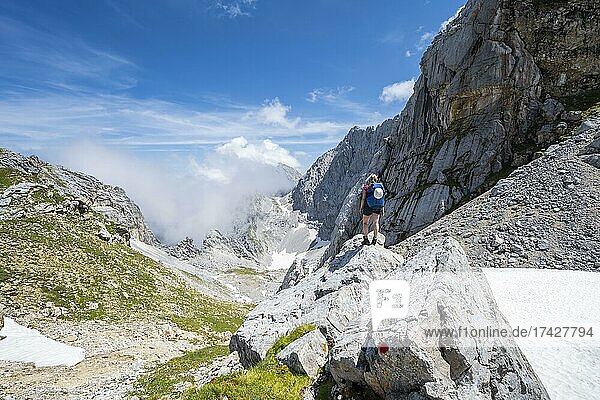 Hiker standing on a rock  hiking trail to the Meilerhütte  Wetterstein Mountains  Garmisch-Partenkirchen  Bavaria  Germany  Europe
