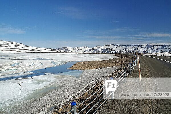 Road leads through barren mountain landscape with snow and ice  Seydisfjördur  Fjarðarheiði  Iceland  Europe