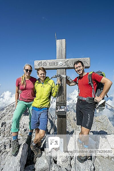 Drei Wanderer am Gipfelkreuz des Hochkalter  Berchtesgadener Alpen  Berchtesgadener Land  Oberbayern  Bayern  Deutschland  Europa
