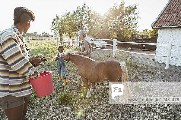 Mehrgenerationenfamilie mit Pferd auf dem Bauernhof