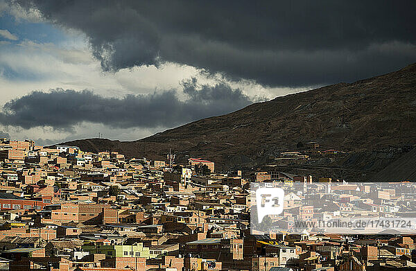 Bolivia  Potosi  Aerial view of city buildings and hill under storm clouds