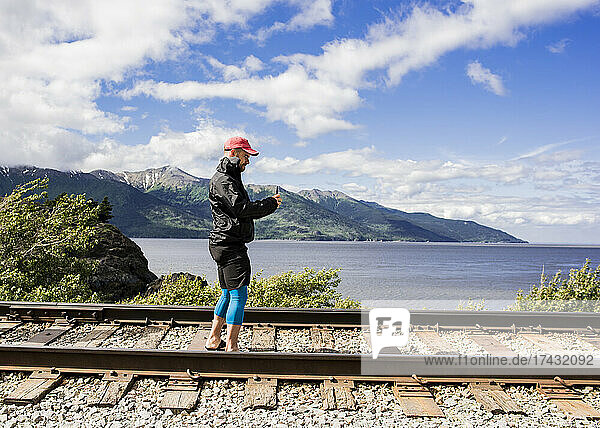 USA  Alaska  Man photographing railroad tracks in Kenai Fjords National Park