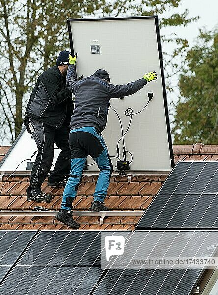 Techniker montieren eine Photovoltaikanlage auf dem Dach eines Wohnhauses in Markt Schwaben  Bayern  Deutschland  Europa