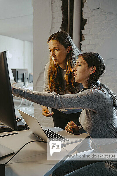 Weibliche Hacker kommunizieren bei der Arbeit am Computer im Büro