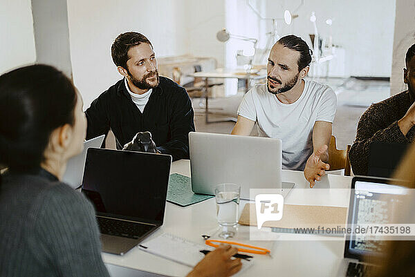 Geschäftsleute beim Brainstorming mit Laptop in einer Besprechung im Büro