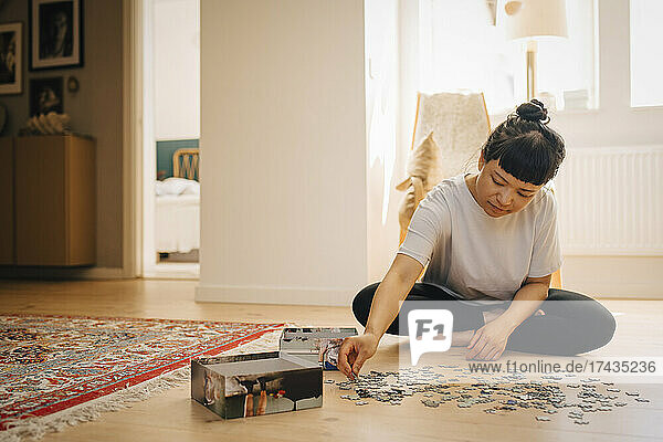 Junge Frau spielt Puzzle zu Hause