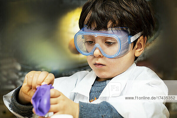 UK  Boy (4-5) making science experiments at home
