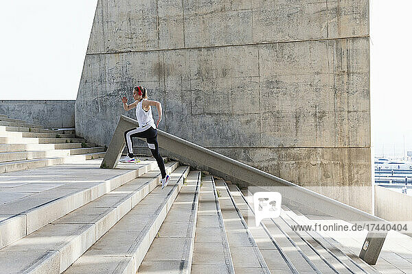Sportswoman jogging on staircase