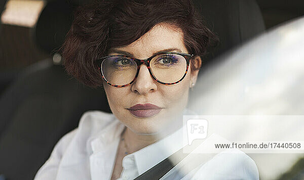 Beautiful businesswoman wearing eyeglasses in car