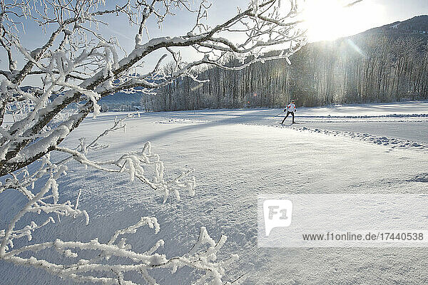 Woman skiing on snow during sunny day
