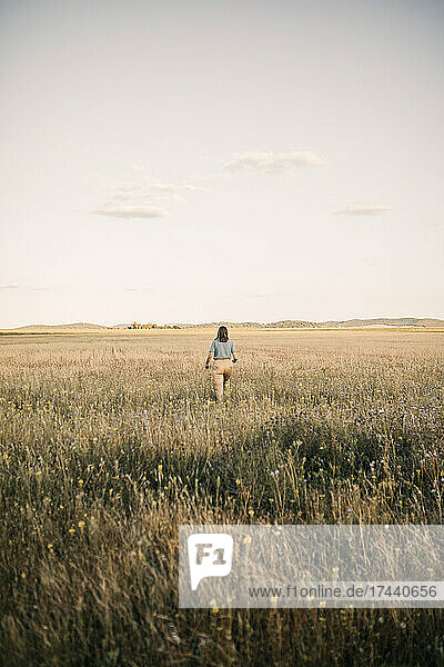 Woman walking amidst plants at agricultural field