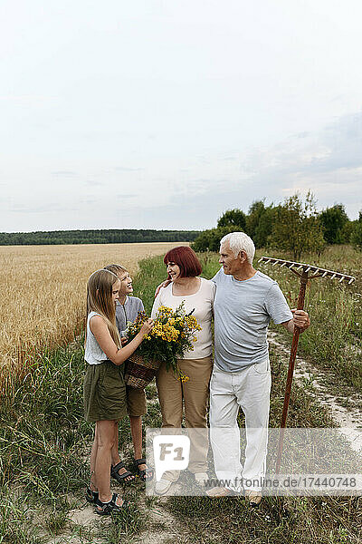 Children and grandparents with flowers on field