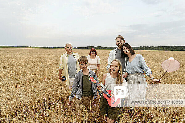 Happy family walking on wheat field
