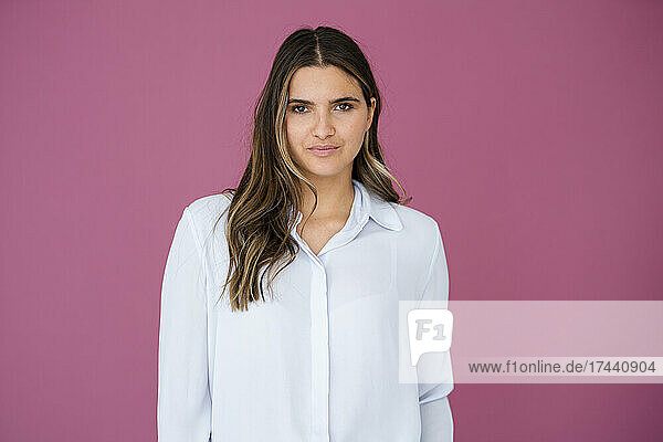 Female business professional in front of pink wall