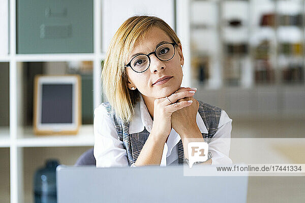 Businesswoman with hand on chin at office