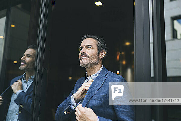 Smiling businessman at doorway of hotel