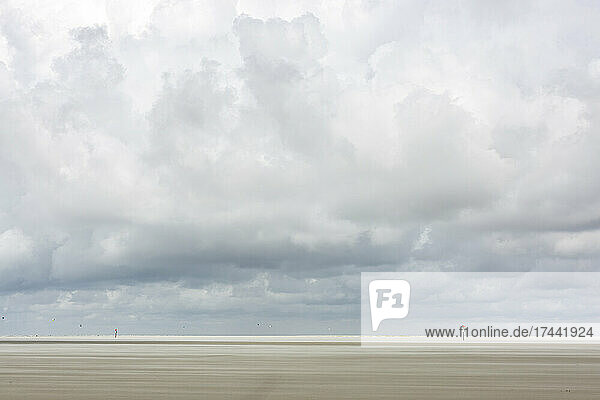 Large clouds over vast empty beach