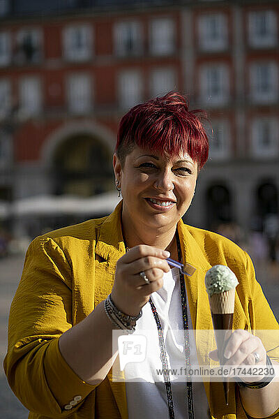 Smiling mature woman eating ice cream