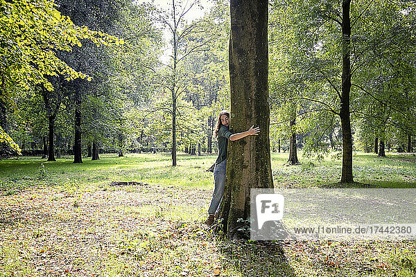 Woman hugging tree in park