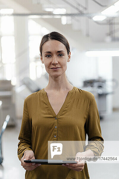 Mid adult businesswoman holding digital tablet in industry