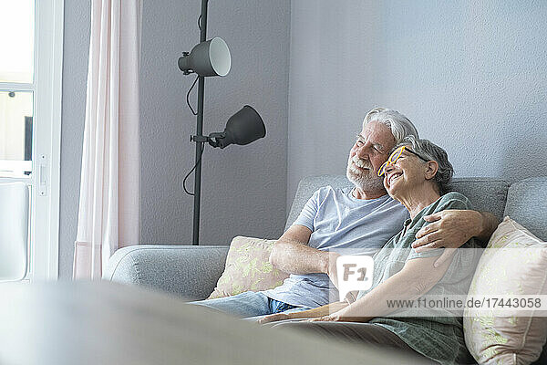 Smiling woman leaning on shoulder of man at home