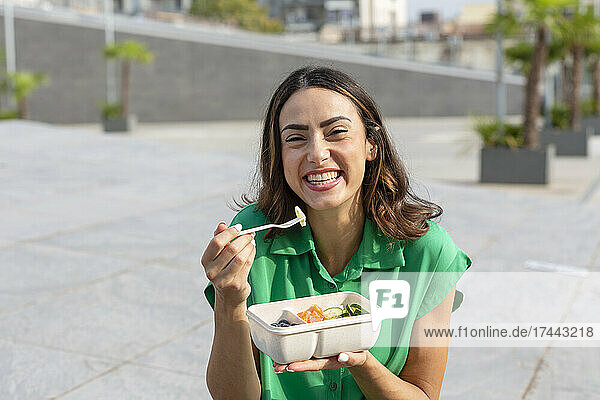 Smiling woman eating lunch
