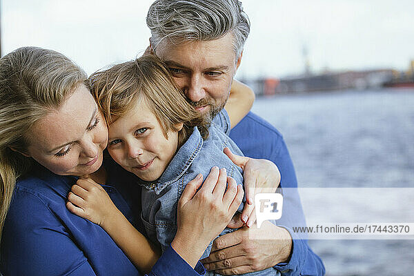 Smiling son embracing mother and father