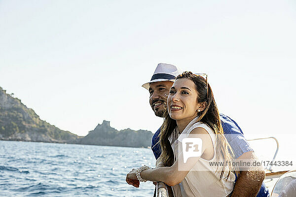 Happy couple standing together in motorboat during sunny day