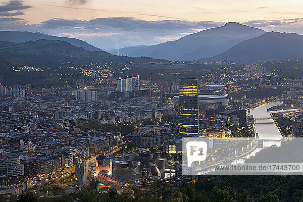 Spanien  Biskaya  Bilbao  Stadt am Flussufer in der Abenddämmerung