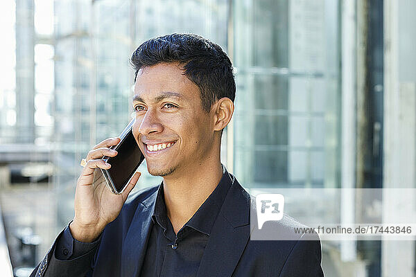 Happy businessman talking on smart phone