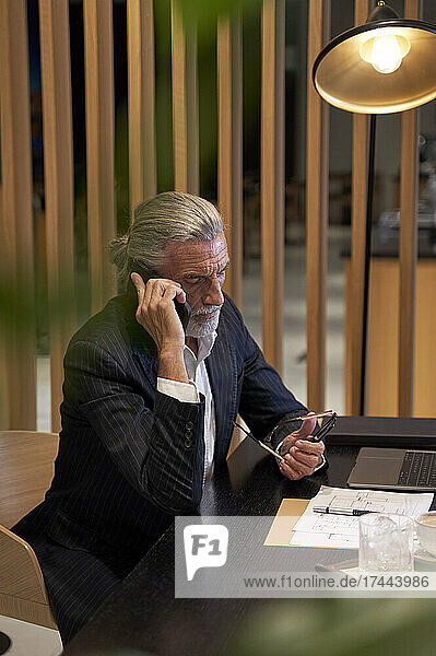 Male business person talking on mobile phone at hotel