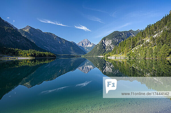 Scenic view of mountains reflecting in Plansee lake