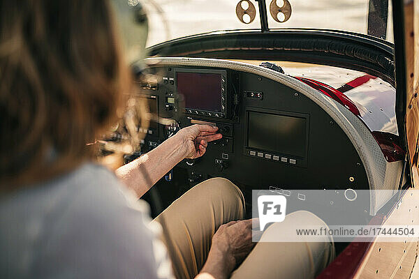 Woman operating dashboard in airplane