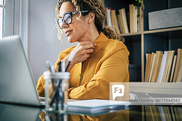 Smiling businesswoman wearing eyeglasses working at home office