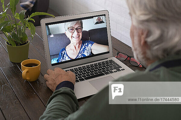 Älterer Mann nimmt zu Hause über Laptop an Videoanruf teil
