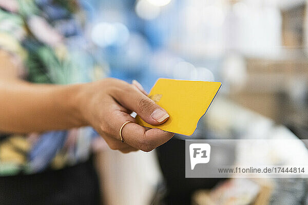 Woman holding credit card at restaurant
