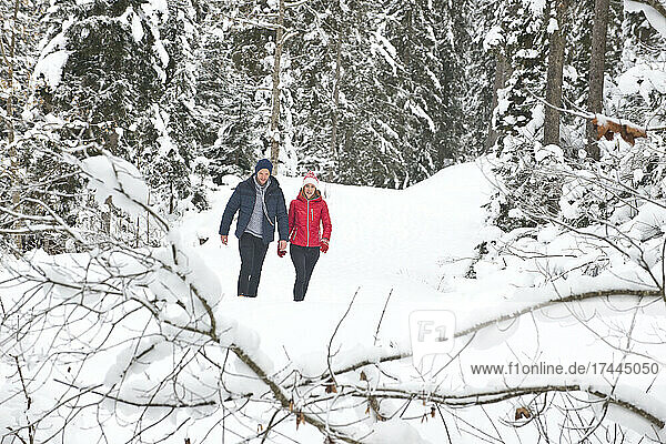Man and woman walking on snow during winter