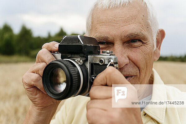 Senior man photographing through camera