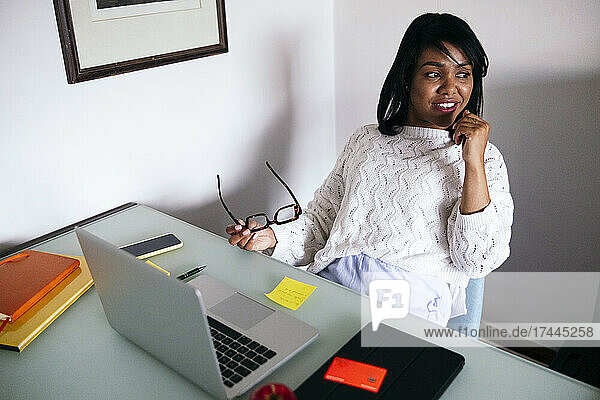 Mid adult female freelancer sitting with laptop at desk