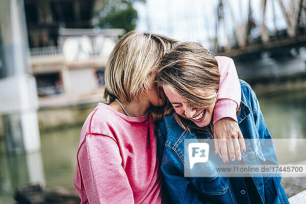 Mother embracing cheerful daughter