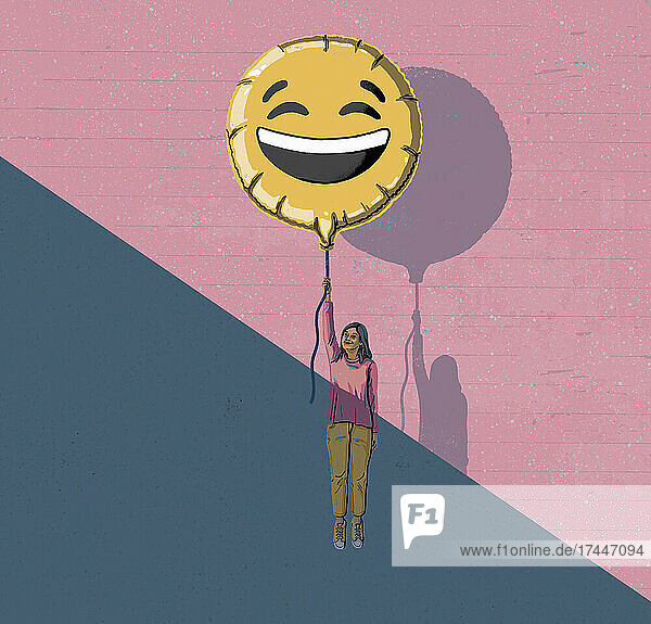 Frau steigt aus dem Schatten auf und hält einen Smiley-Ballon