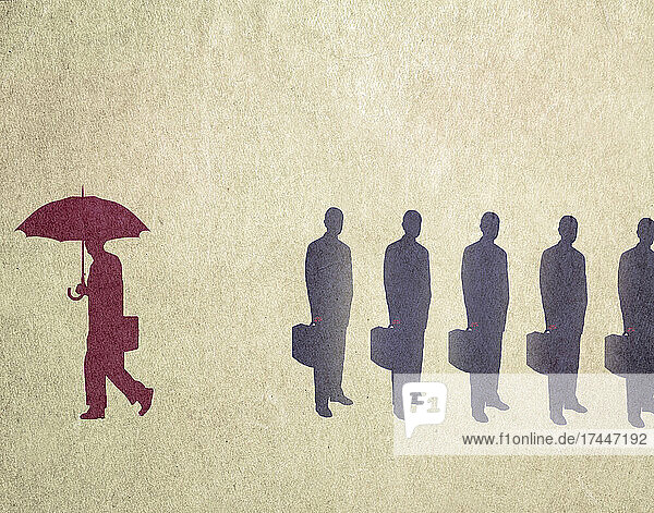 Geschäftsmann mit Regenschirm entfernt sich von der Menge